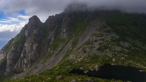 Dramatic Cliff Face with Alpine Lake in Lofoten Norway 스톡 사진