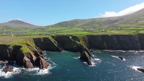 Dramatic Cliffs and Atlantic Ocean with Green Fields at Dunquin Pier Stock Footage 336631245