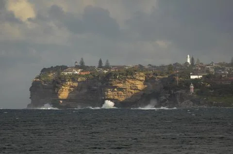 Dramatic cliffs and coastal homes under a moody sky in Sydney, Australia. Stock-Fotos