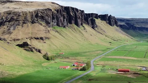 Dramatic Cliffs and Red Roofed Buildings in Icelandic Landscape Stock Footage 296555612