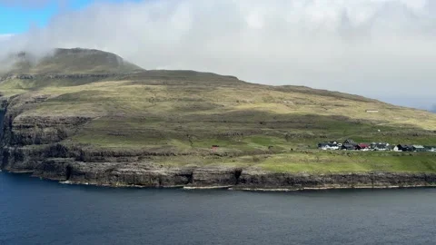 Dramatic cliffs and remote village on the Faroe Islands  Stock Footage 310947788