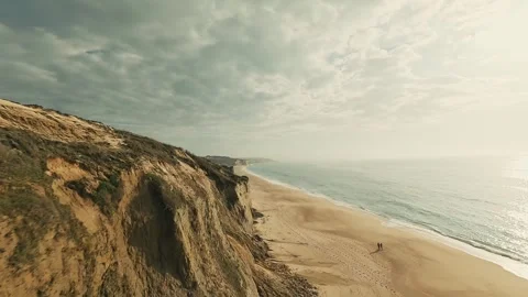 Dramatic cliffs meet gentle waves below Stock Footage 340226483
