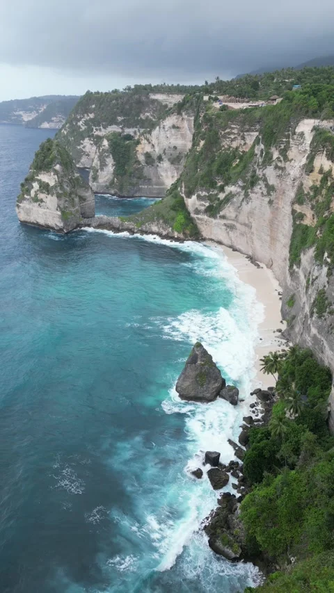 Dramatic cliffs with powerful waves and a hidden beach on the coast, aerial Stock Footage 340532948