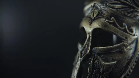 Dramatic close up of gladiator armor helmet rotating, illuminated by soft Stock Footage 334162054