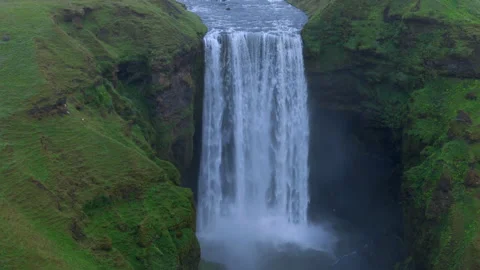 Dramatic Close-Up of a Lush Green Cliff with a Powerful Waterfall Cascading Down Stock Footage 274860078