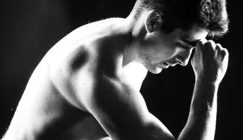 Dramatic close-up of a man thinking with a fist on his forehead Stock Photos