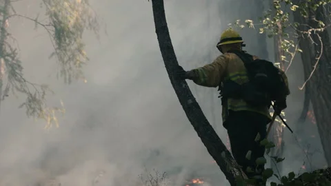 Dramatic Close Up POV of Firefighter standing amongst the smoke and flames Stock Footage 201346891