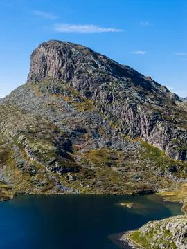 Dramatic close-up of a rugged mountain and tranquil lake. Stock Photos
