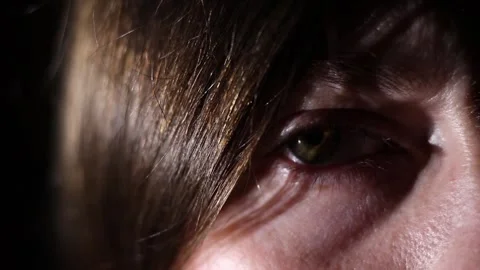 Dramatic close-up shot of an eye against a deep black background Stock Footage 347456839
