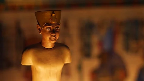 Dramatic Closeup of Old Egyptian Figure Statue Papyrus Background Stock Footage 75267203