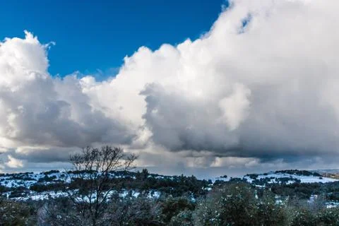 Dramatic cloud filled sky on a cold winter day with snow covered hills in Stock Photos