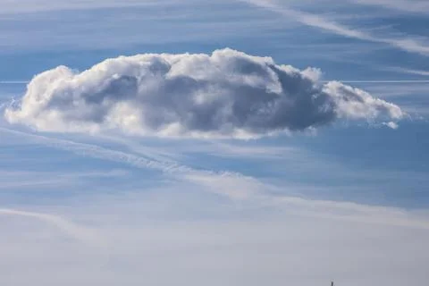 Dramatic cloud formation against a bright blue sky with contrails 스톡 사진