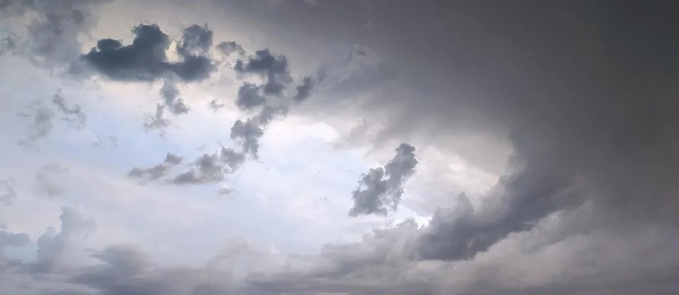 Dramatic cloud formation fills the sky during an overcast evening, hinting .. Stock Photos