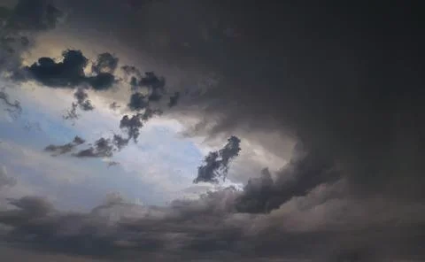 Dramatic cloud formation fills the sky during an overcast evening, hinting .. Stock Photos