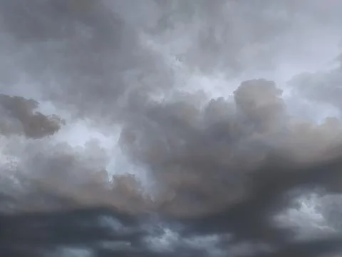 Dramatic cloud formation fills the sky during an overcast evening, hinting .. Stock Photos