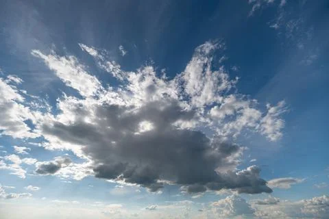 Dramatic cloud formation over bright blue sky at low sun Stock Photos