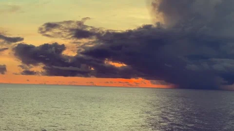 Dramatic cloud formation over calm ocean at sunset with orange and purple h.. Stock Footage 338280334