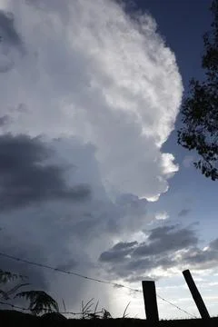 Dramatic Cloud Formation Over Rural Landscape with Silhouetted Fence Fotos de archivo