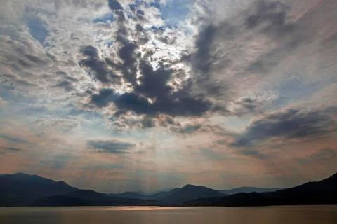 Dramatic cloud formation sunbeams behind dark clouds thunderstorm atmosphere Stock Photos