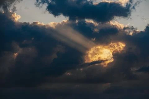Dramatic cloud formation with sunlight breaking through, showcasing rays of.. 写真素材