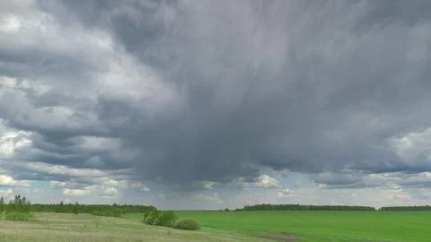 Dramatic Cloud Formation Towering Over Lush Green Fields Stretching Across the H 写真素材