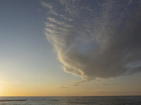 Dramatic cloud formations over a calm sea at dusk, zingst, baltic sea, germany Stock Photos