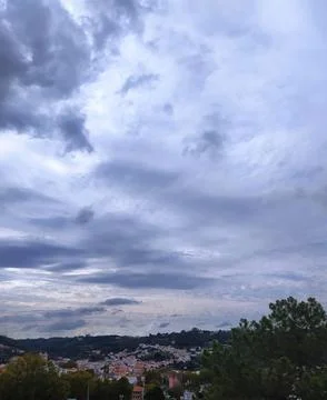Dramatic cloud formations over a hillside town in the late afternoon sunlig.. 스톡 사진