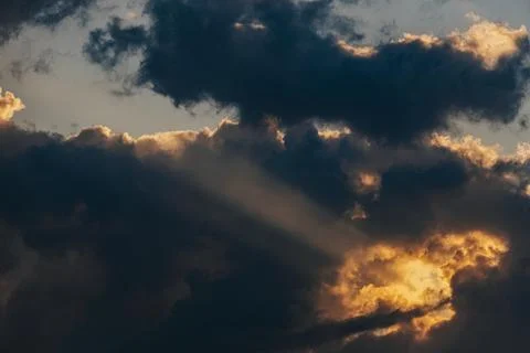 Dramatic cloud formations with rays of sunlight breaking through, creating .. Stock Photos