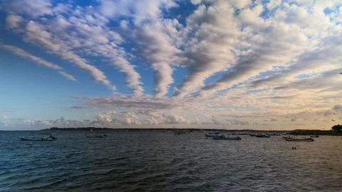 Dramatic Cloud Formations Spreading Across the Sky Above Fishing Boats Stock Photos