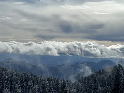 Dramatic Cloud Layer Over Winter Mountain Forest Foto stock