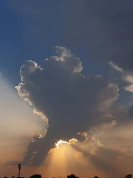 Dramatic cloud with sun rays bursting from behind Stock Photos