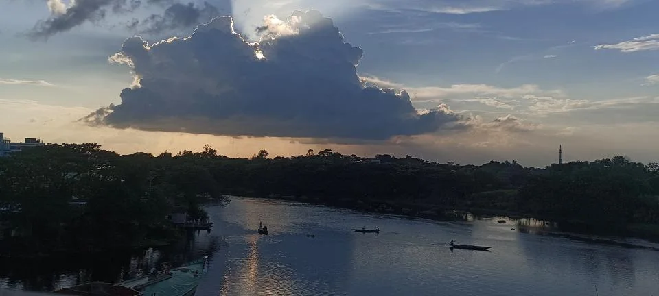 Dramatic cloud with sun rays over river and boats sunset landscape HD Foto stock