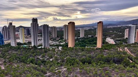 Dramatic Cloudfilled Sky Highlights Urban Development And Natural Landscape Stock Photos