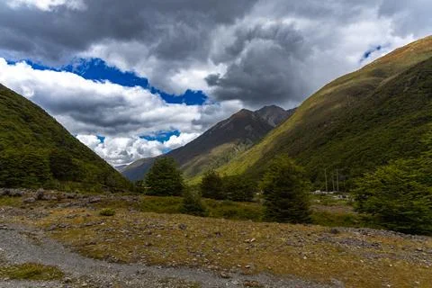 Dramatic Clouds Above Lush Green Mountain Valley Foto stock