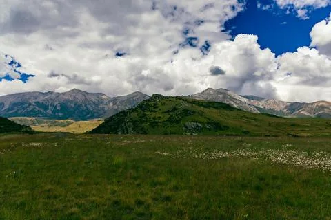 Dramatic Clouds Above Remote Mountain Meadow Landscape Foto stock