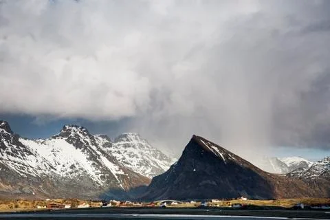 Dramatic clouds above remote, snowy mountains, Fredvang, Lofoten Foto stock