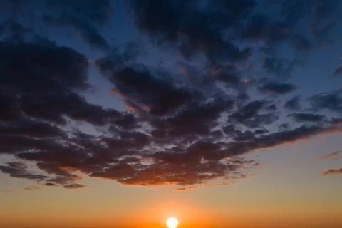 Dramatic clouds across dusk sky. Dramatic clouds in panoramic sky. Backlit Stock Photos