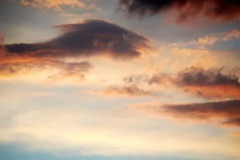 Dramatic clouds and sky in the night. Lights of a sunset through the cloudscape Stock Photos