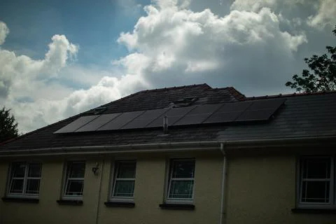 Dramatic clouds and sky over house with rooftop solar panels Stock Photos