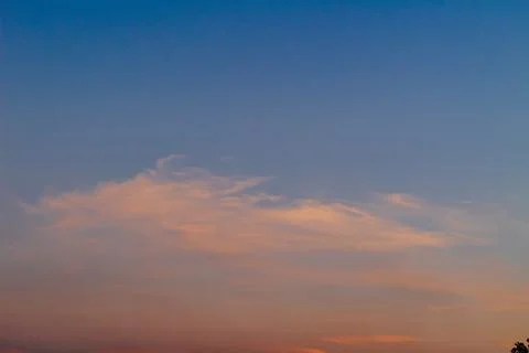 Dramatic clouds in the blue sky in the morning, the rising sun rays hitting.. Stock Photos