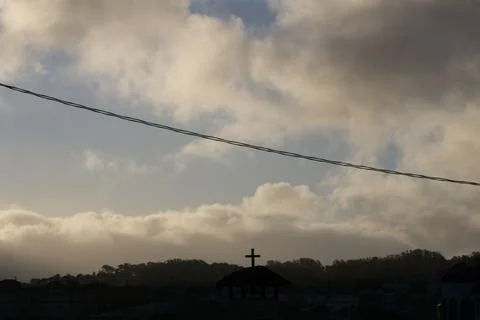Dramatic Clouds A Cross and A Telephone wire Foto stock