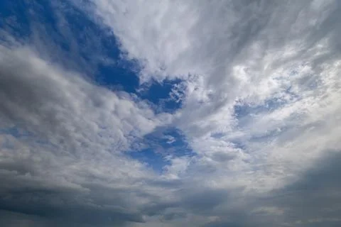 Dramatic clouds dance across the sky revealing hints of blue amid the swirl.. Stock Photos