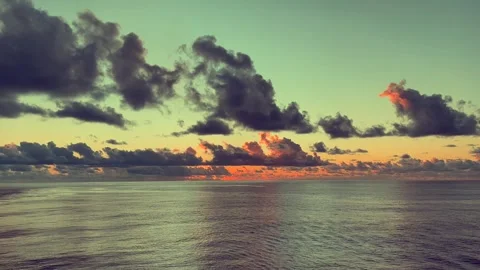 Dramatic clouds fill the evening sky over a tranquil ocean at sunset creati.. Stock Footage 338281810