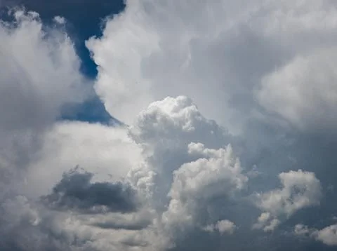 Dramatic clouds filling vast blue sky during daytime Stockfoto's
