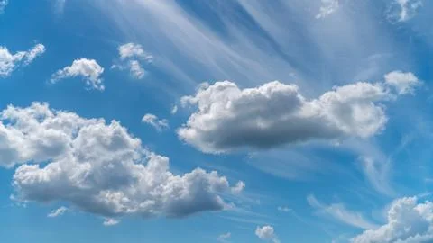 Dramatic clouds float across the blue sky Stock Photos