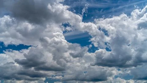 Dramatic clouds float across the blue sky Stock Photos