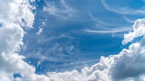 Dramatic clouds float across the blue sky Stock Photos
