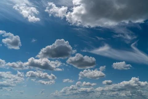 Dramatic clouds float across the blue sky Stock Photos