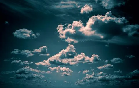 Dramatic clouds float across the blue sky Stock Photos