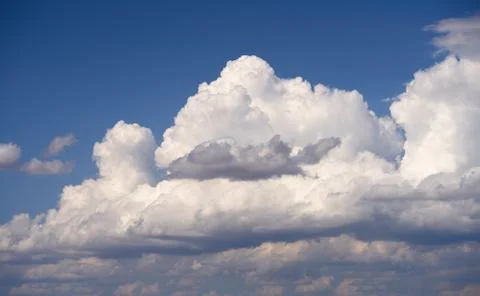 Dramatic clouds float across the blue sky Stock Photos